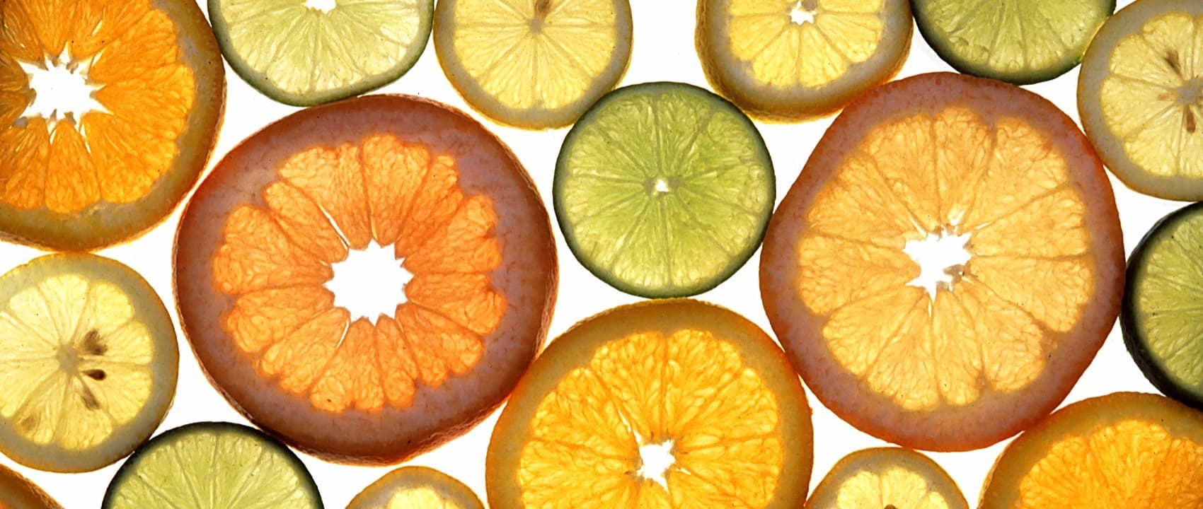 Slices of orange, lemon and lime, lit from behind
